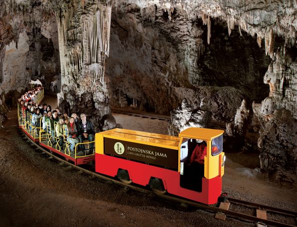 Turistični vlakec v Postojnski jami, ki obiskovalce vodi skozi veličastni podzemni svet.