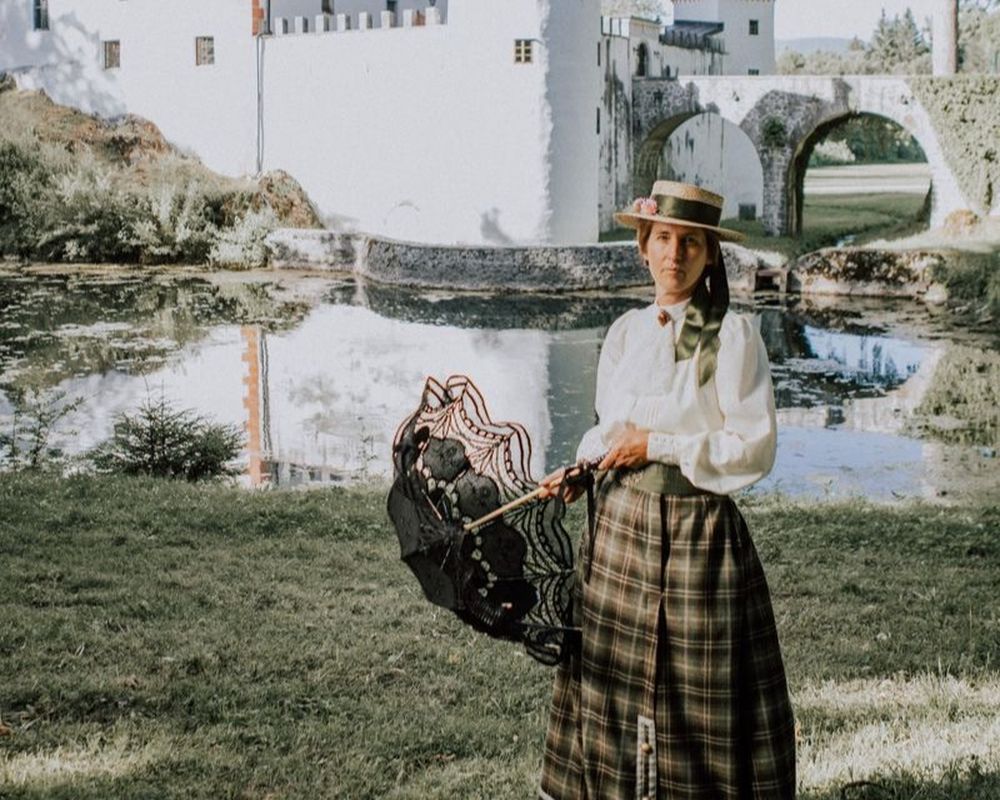 Lokalna turistična vodnica, oblečena kot grofica Greta, ob kraški reki in zgodovinskem mostu na Zelenem krasu. Interpretacijsko doživetje o zgodovini, kulturni dediščini in lokalnih zgodbah.